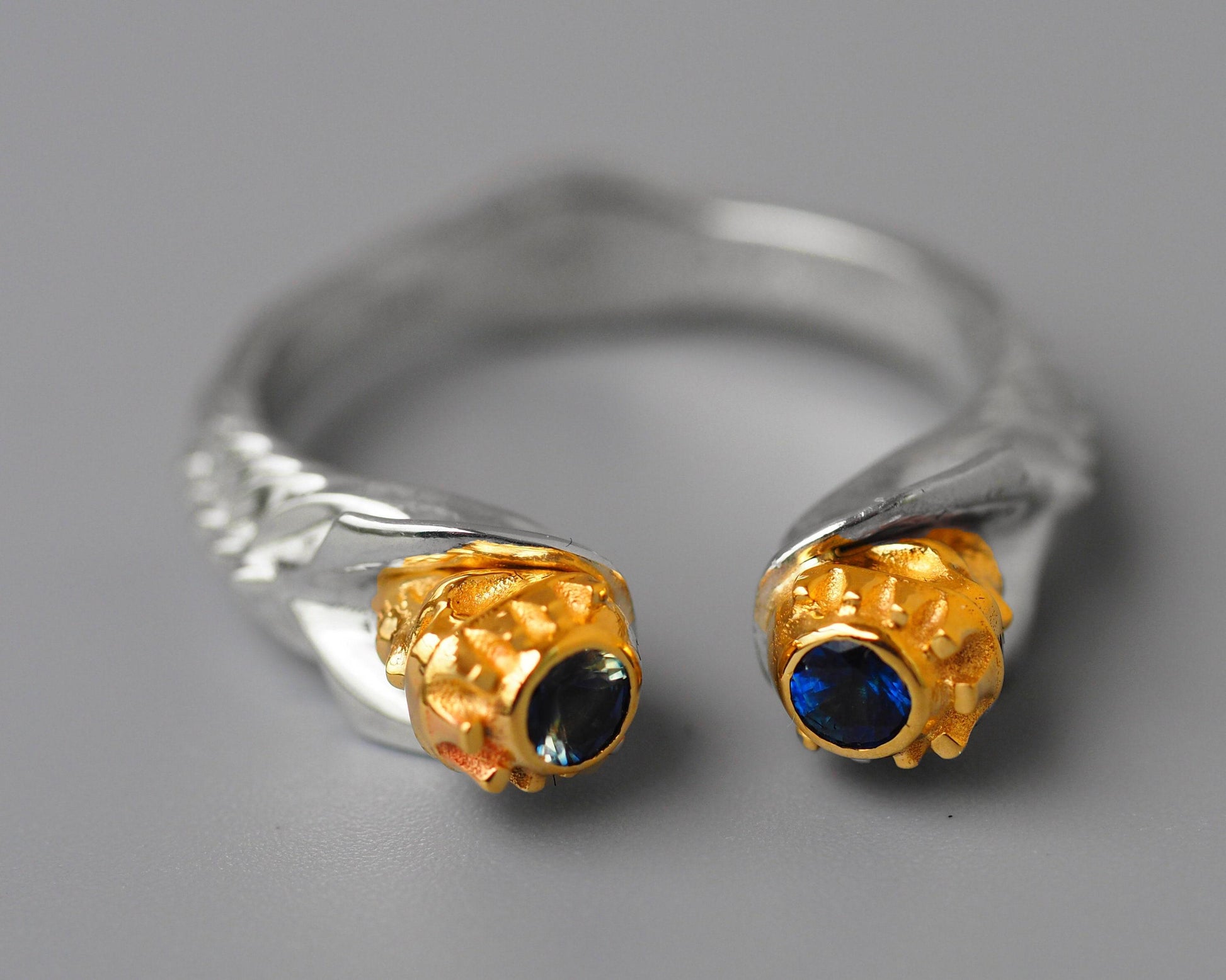 Skull ring with blue sapphires in 14k gold